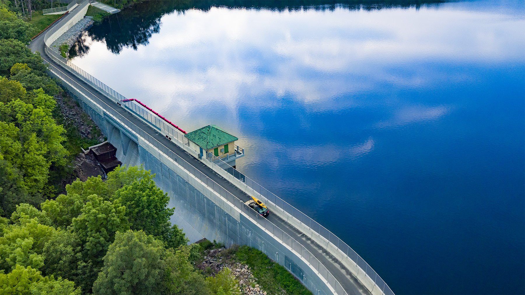 Aerial Drone photograph of car with a kayak on roof crossing the Split Rock Dam