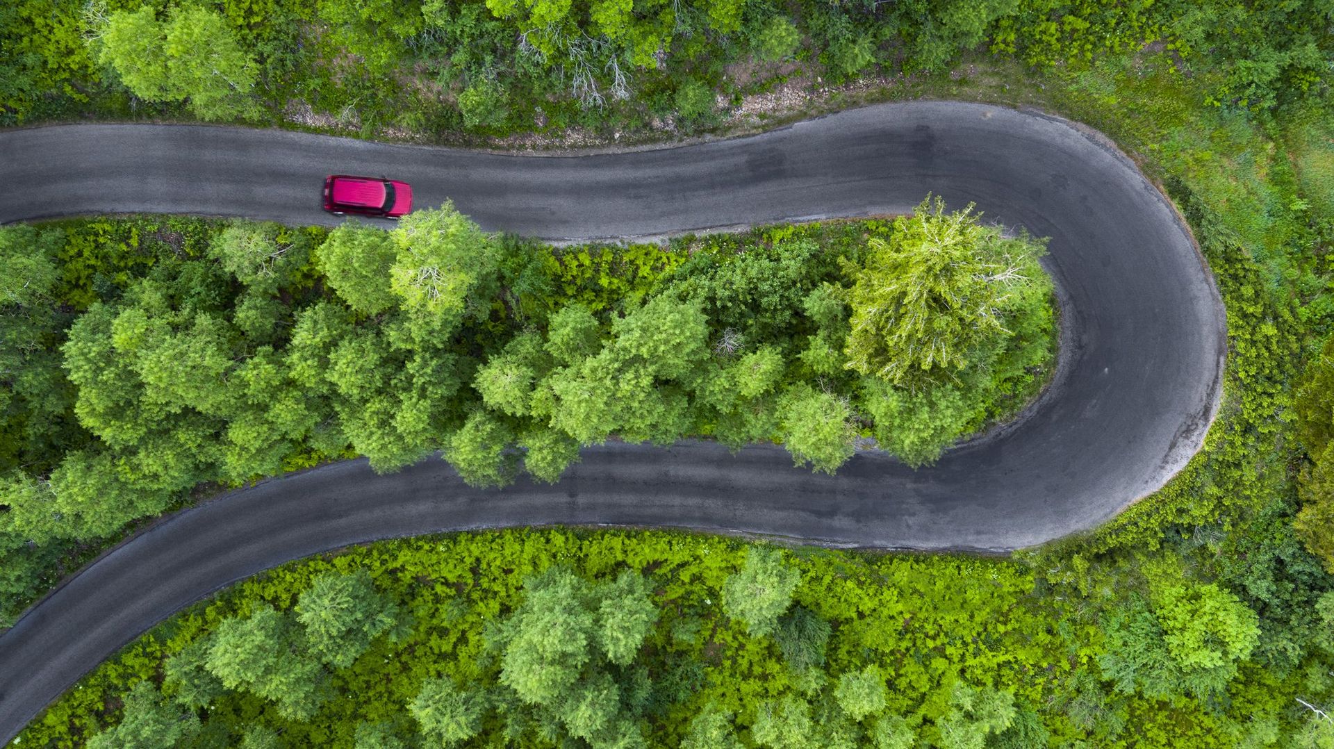 Aerial Drone Photography of Hairpin turn with red car Utah