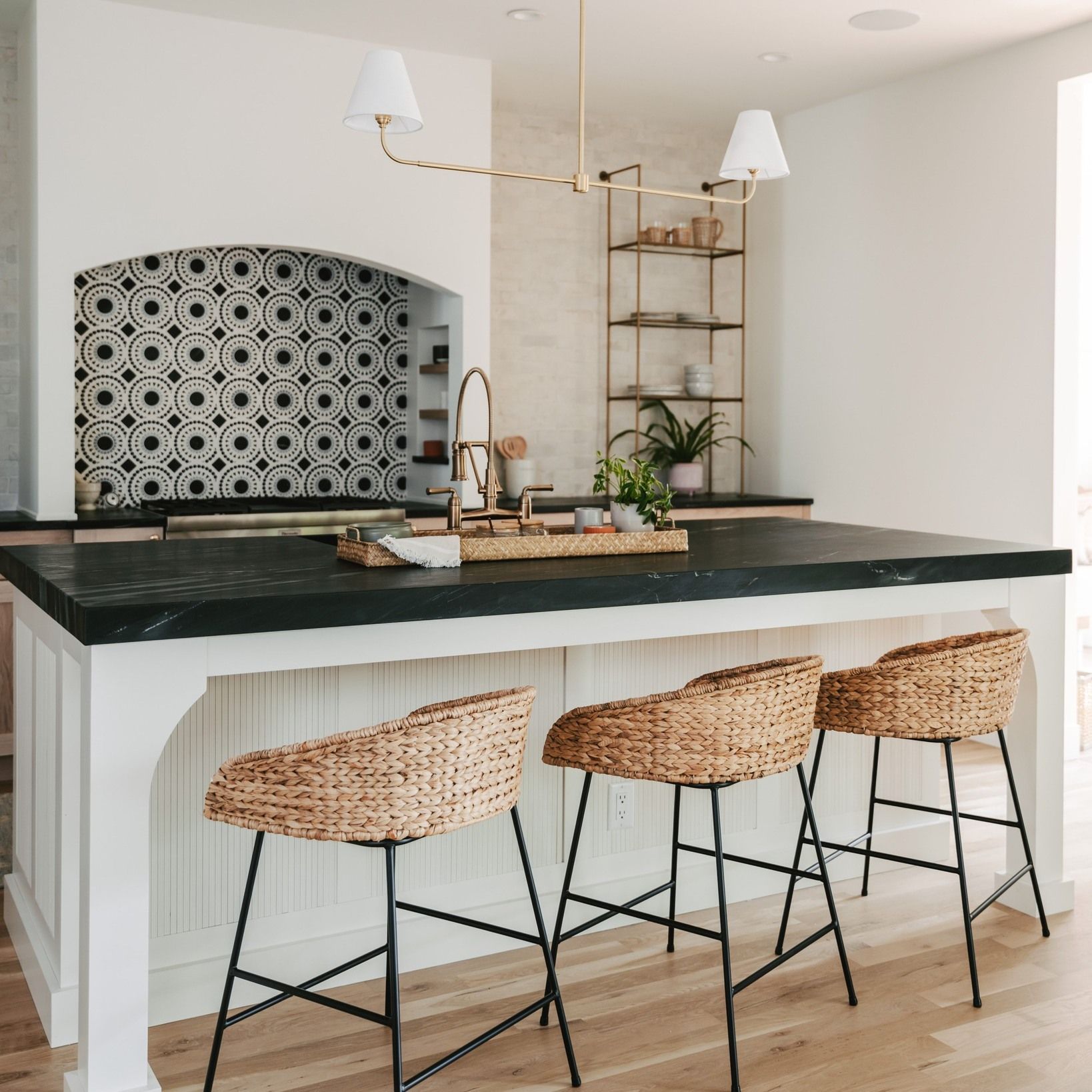 A kitchen with a large island and wicker stools