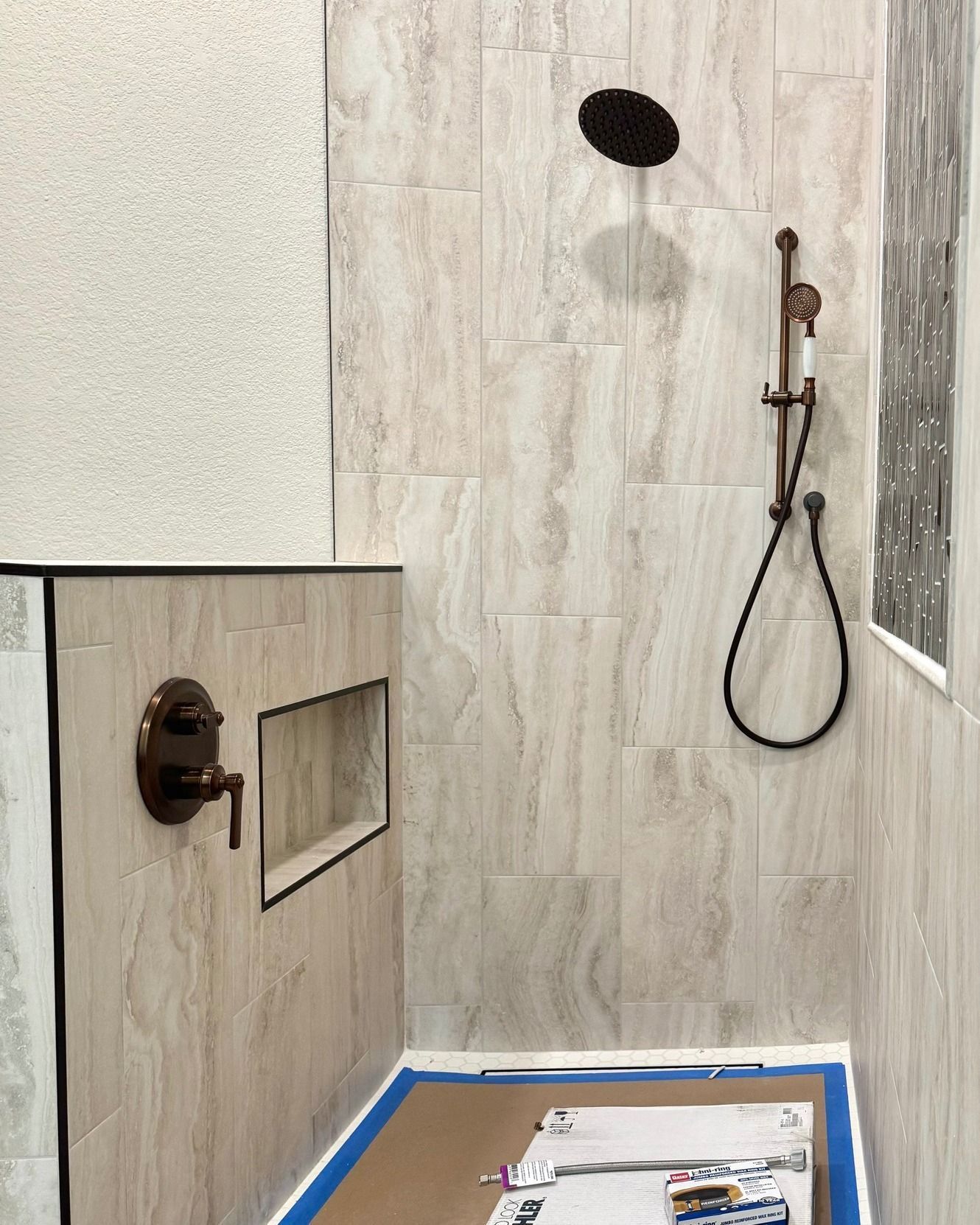 A bathroom with a shower and a blue tape on the floor