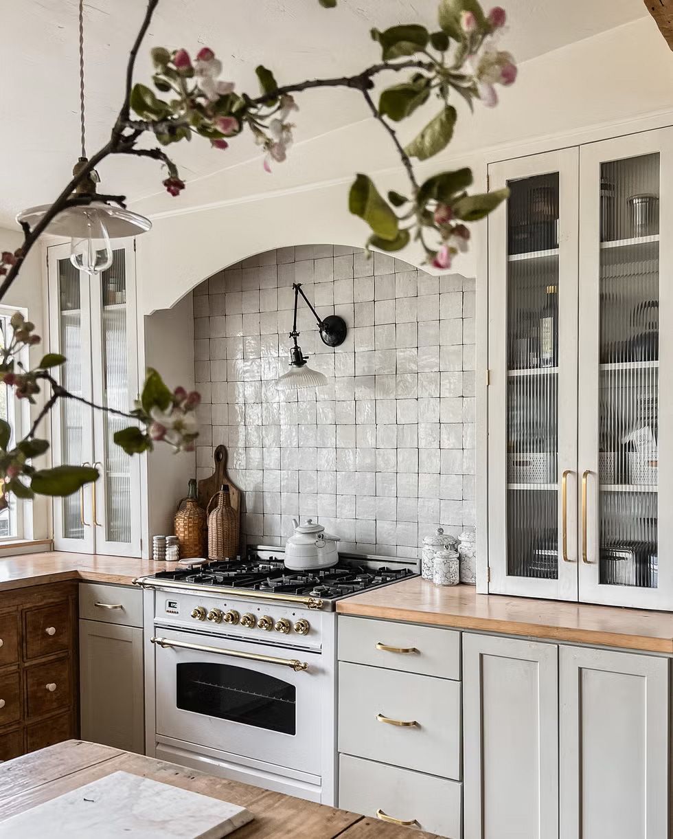 A kitchen with white cabinets and a stove top oven