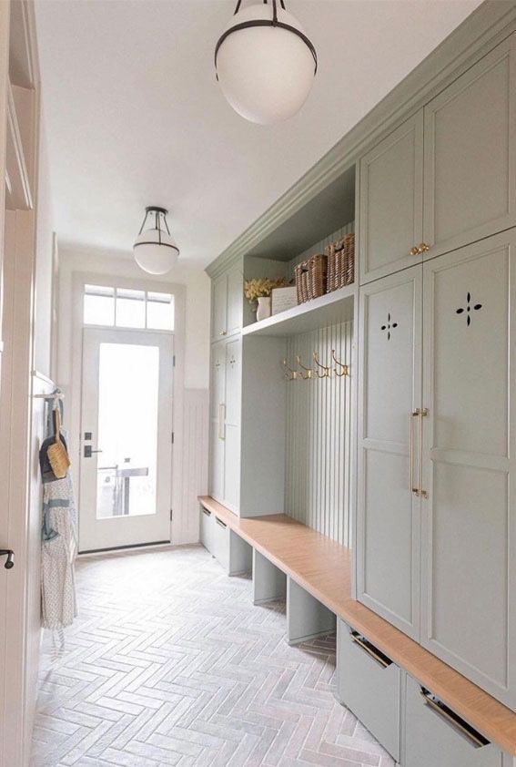 A hallway with lots of cabinets and a wooden bench.