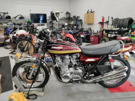 A motorcycle is parked in a garage with other motorcycles.