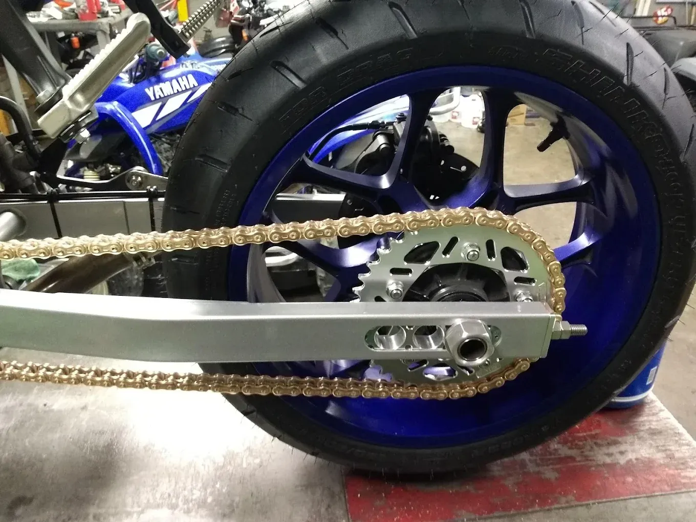 A close up of a motorcycle wheel with a chain attached to it