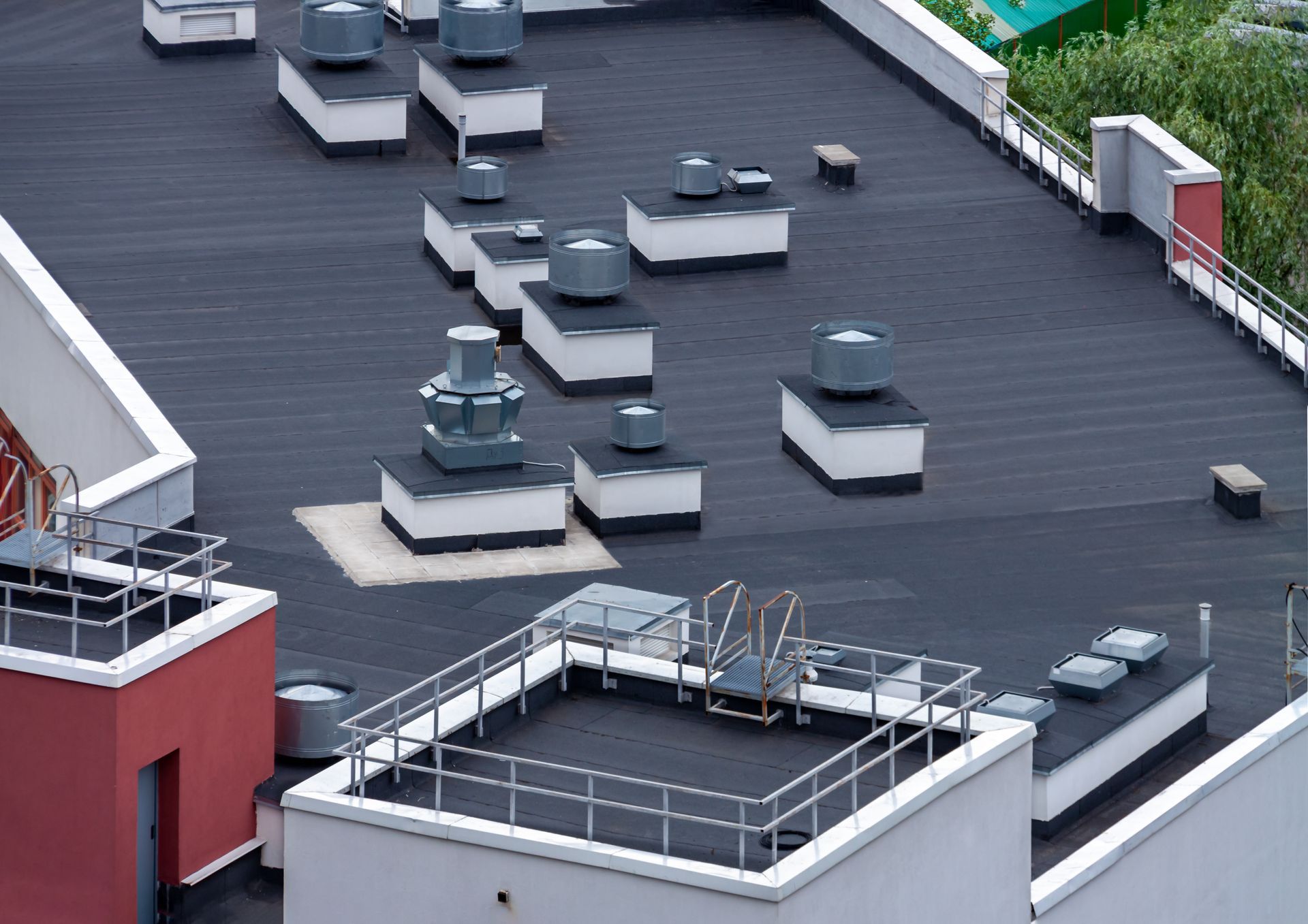 Rooftop with several HVAC units and vents on a flat black roof