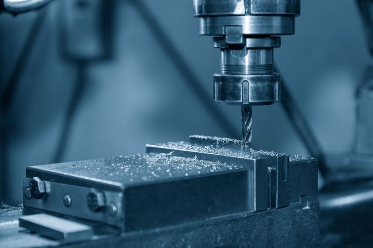 A machine is cutting a piece of metal in a factory.