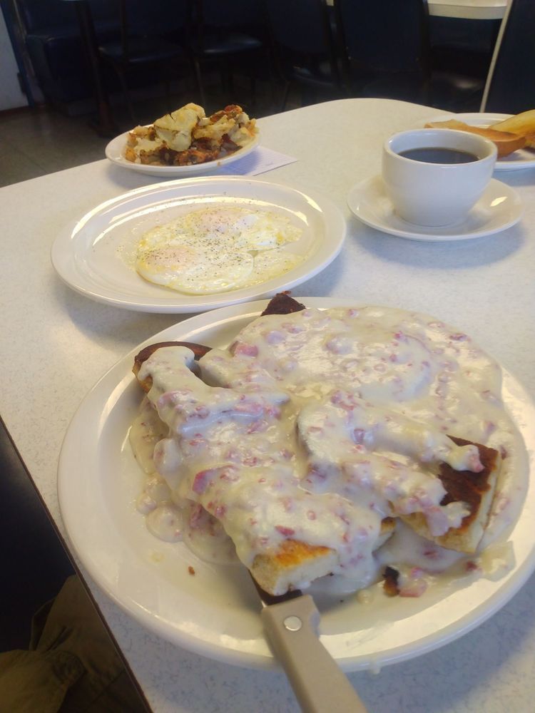 A table topped with plates of food and a cup of coffee.