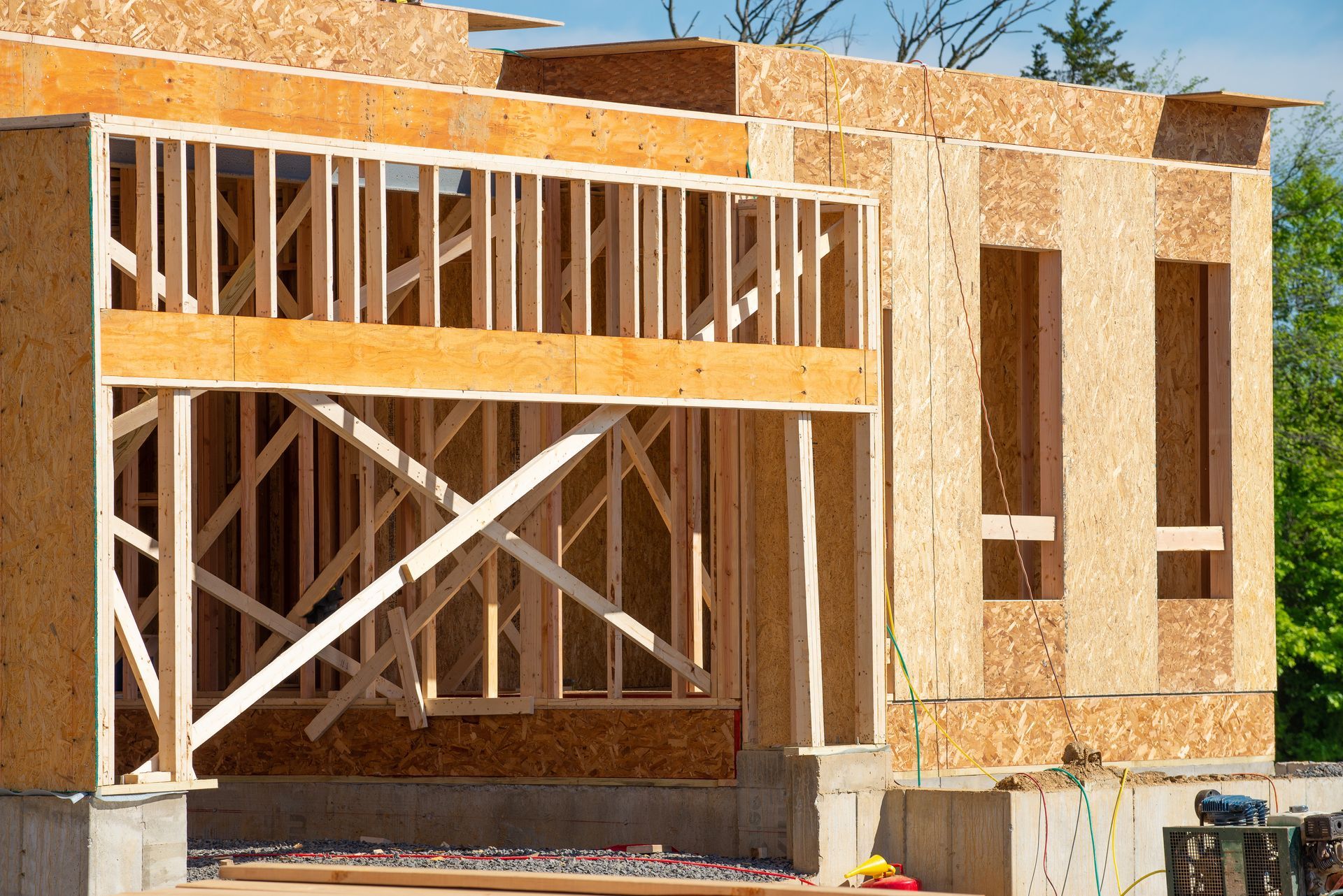 Wooden frame of a house under construction with oriented strand board siding.