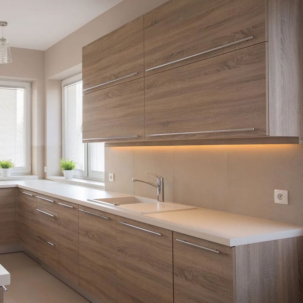 A kitchen with wooden cabinets and a white counter top.