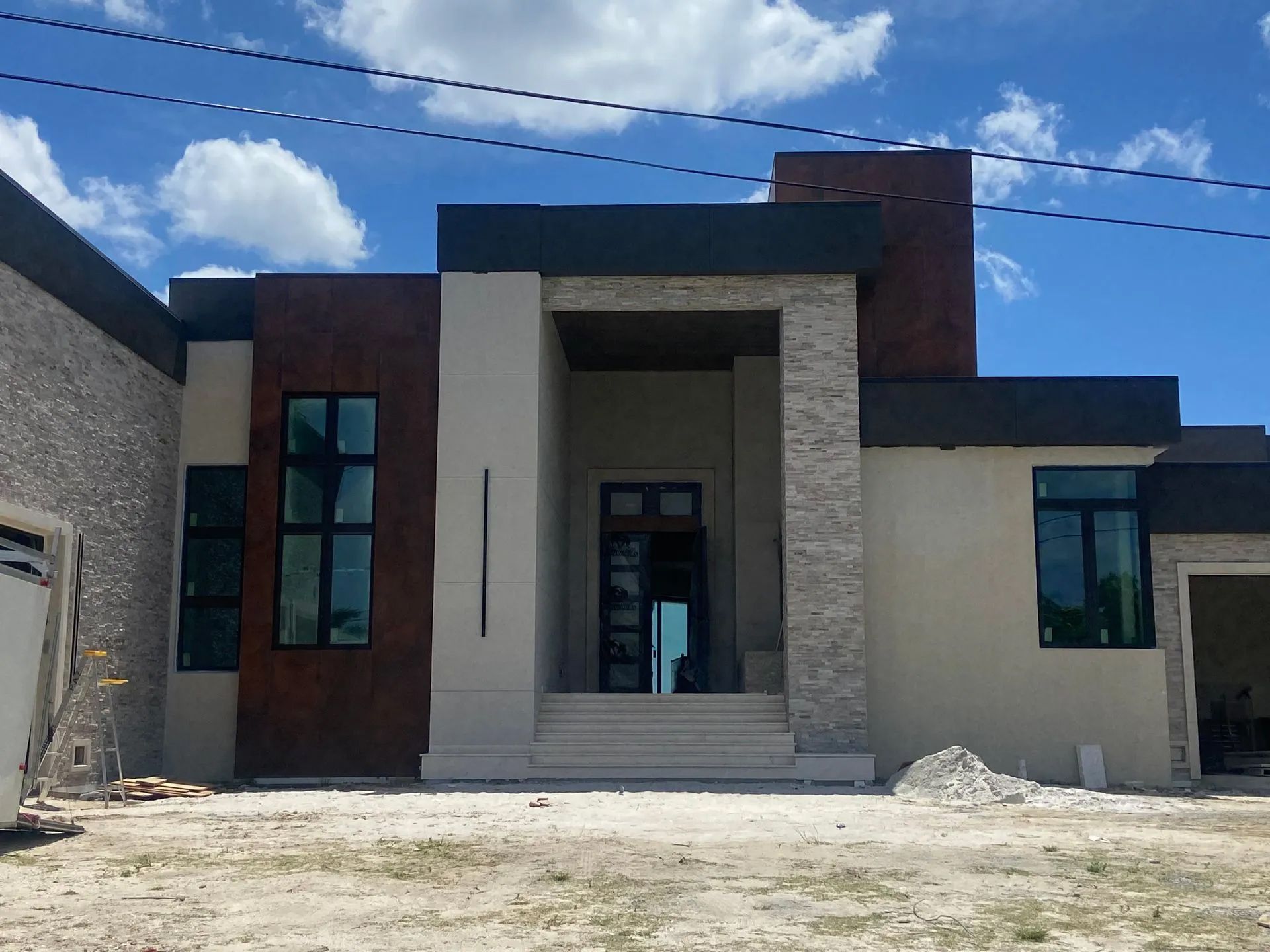 A modern house with a lot of windows is being built.