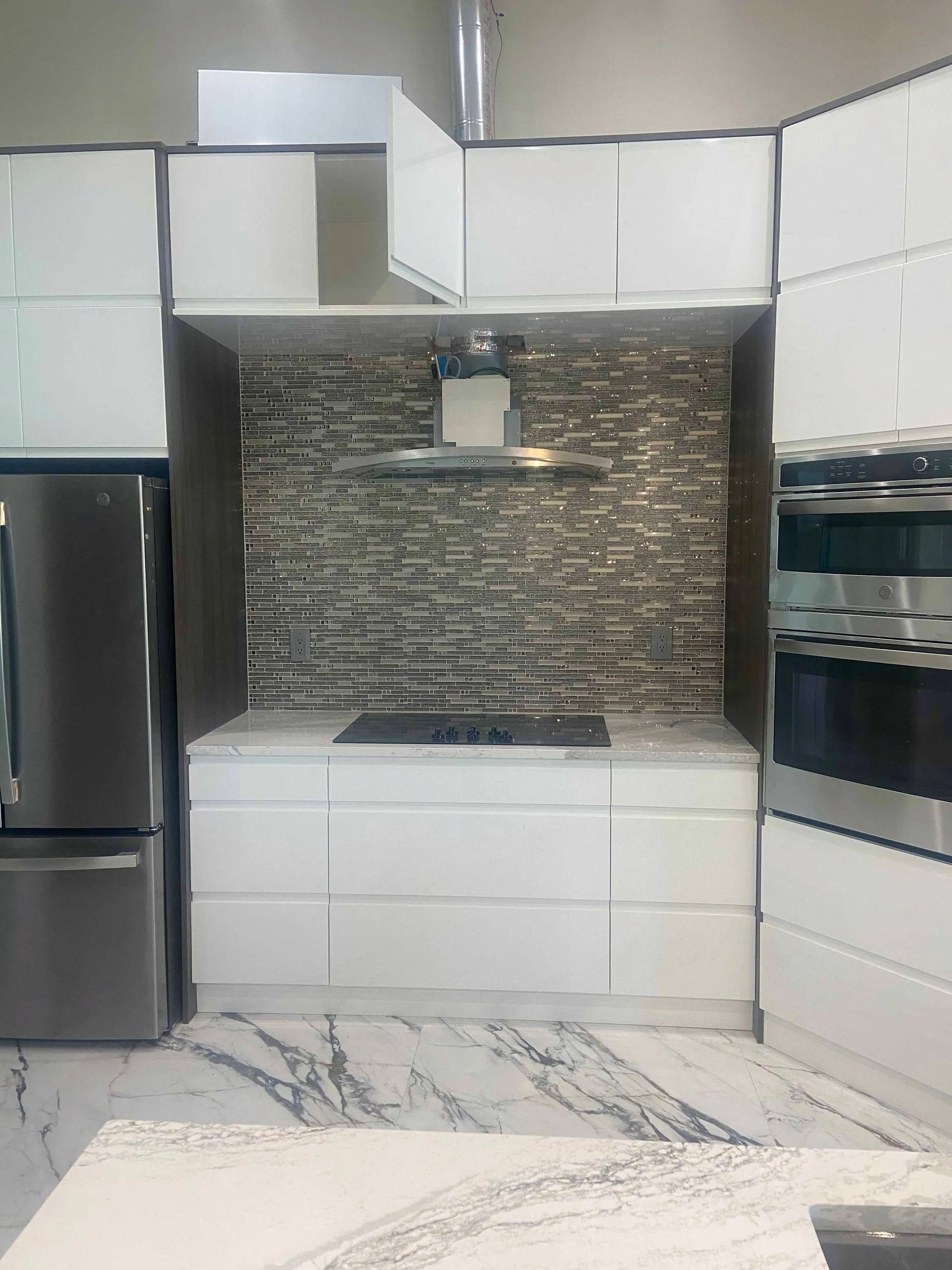 A kitchen with white cabinets and stainless steel appliances.