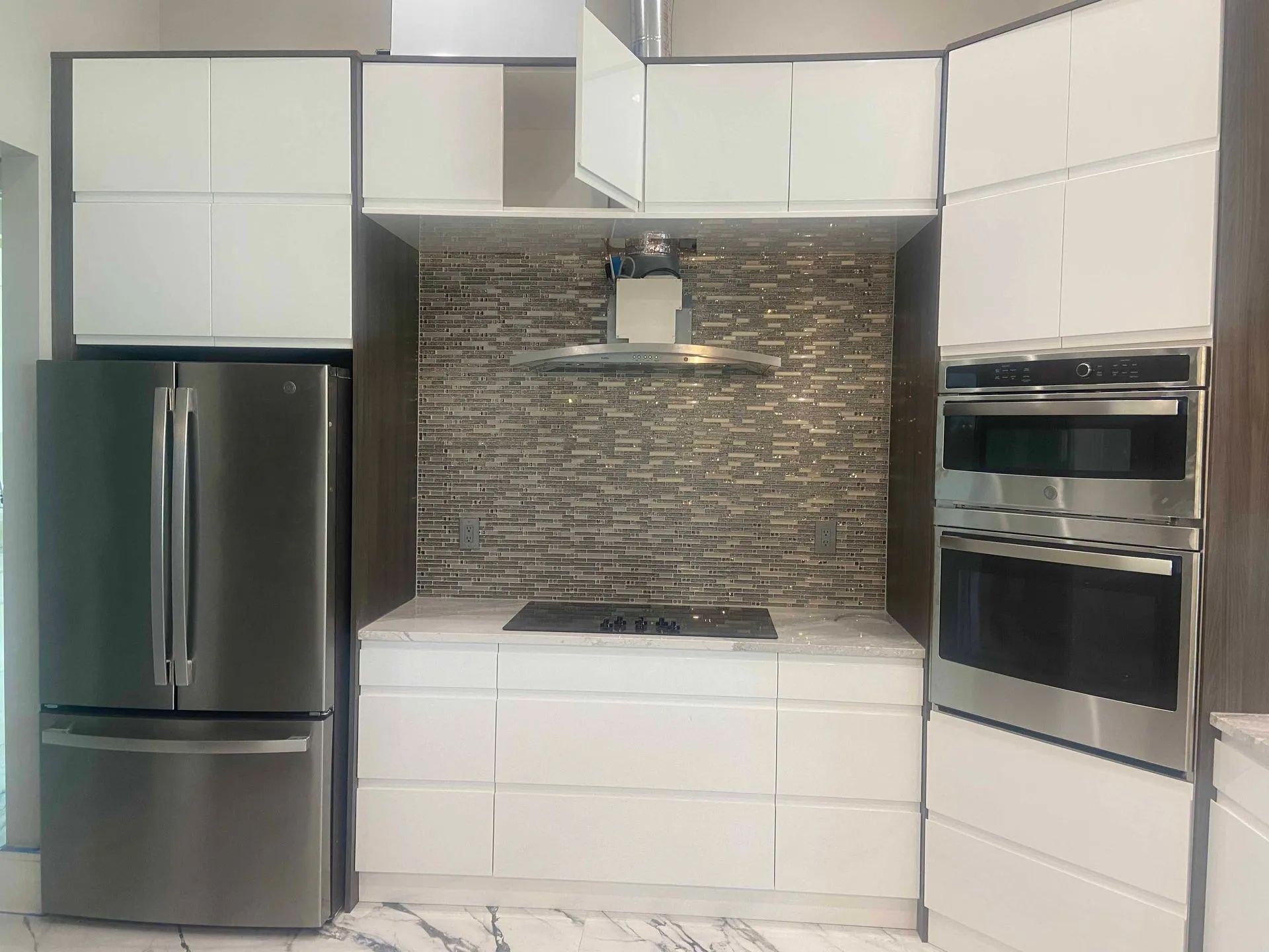 A kitchen with stainless steel appliances and white cabinets.