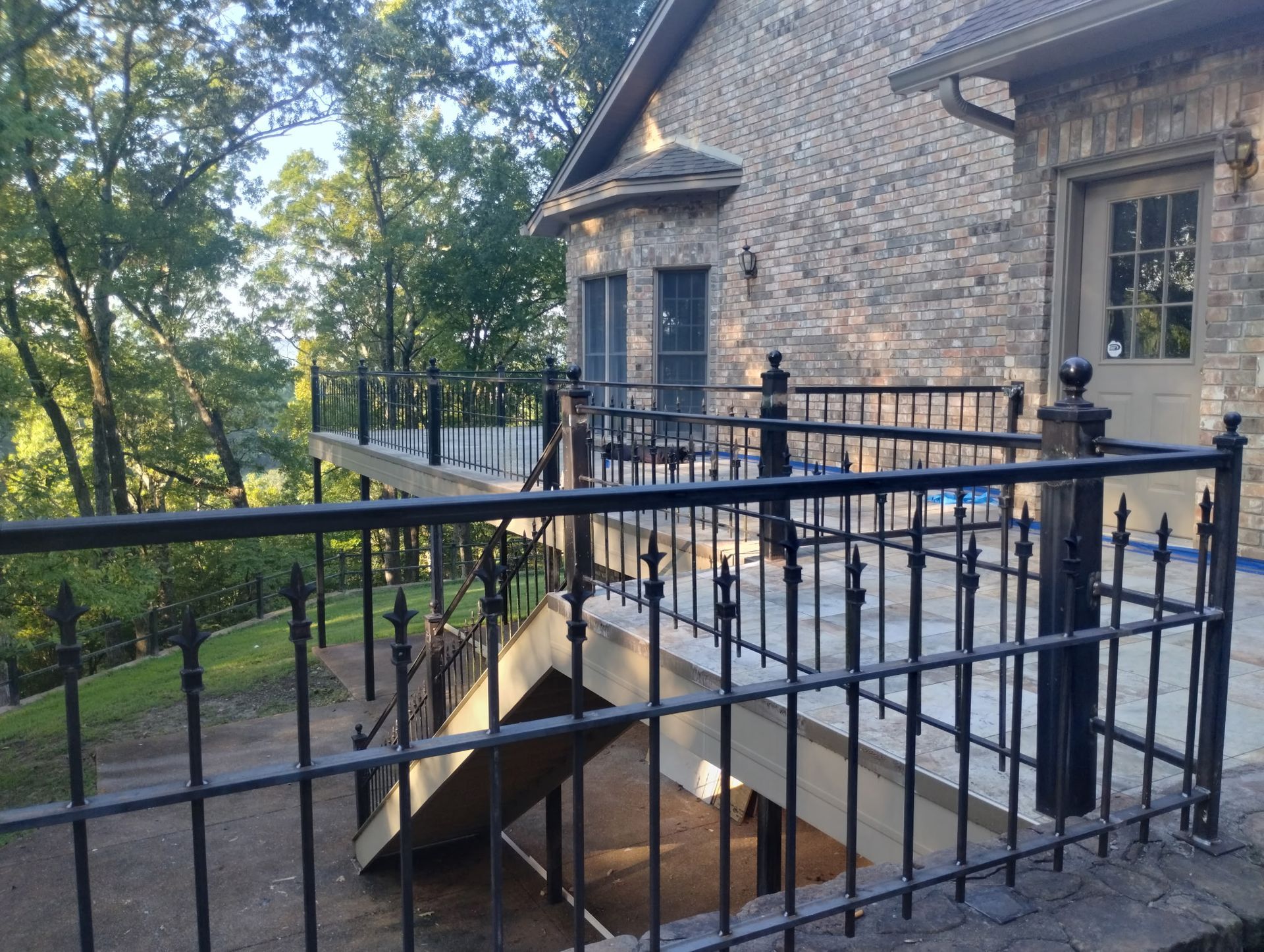 A brick house with a wrought iron fence around it