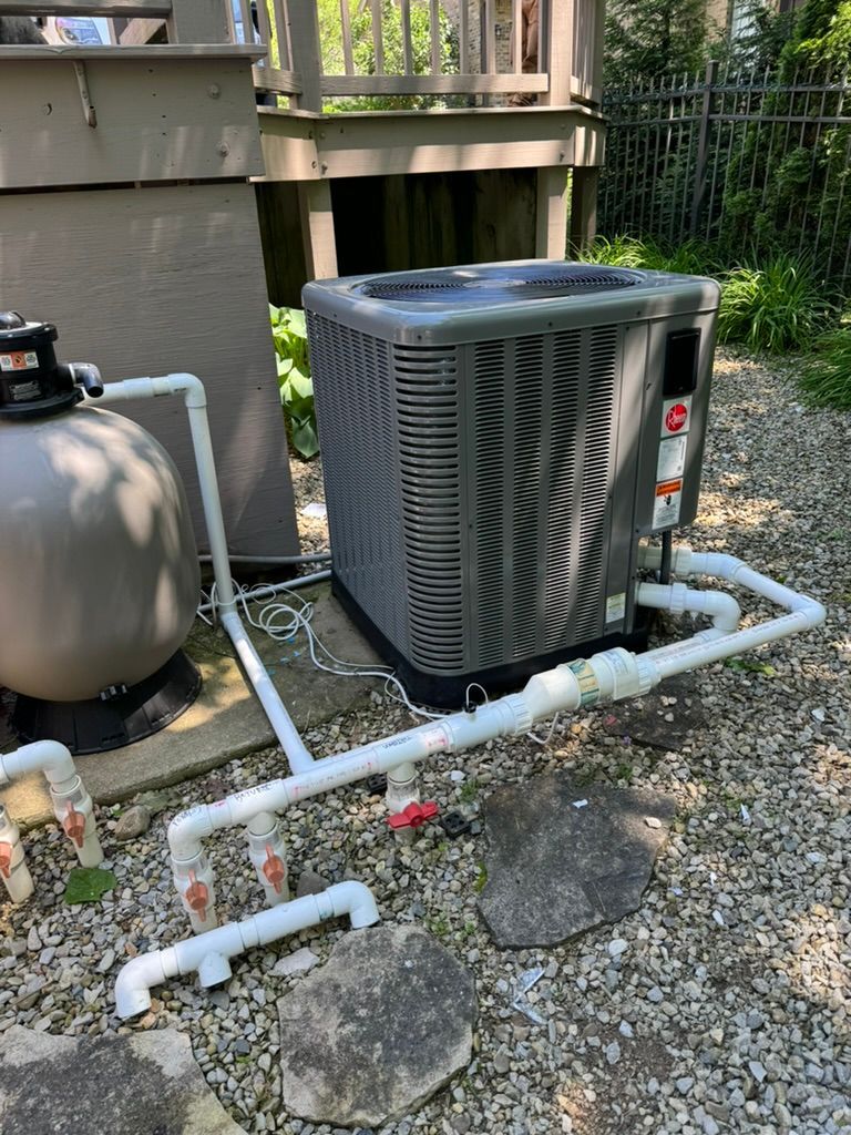 An air conditioner is sitting next to a pool filter.