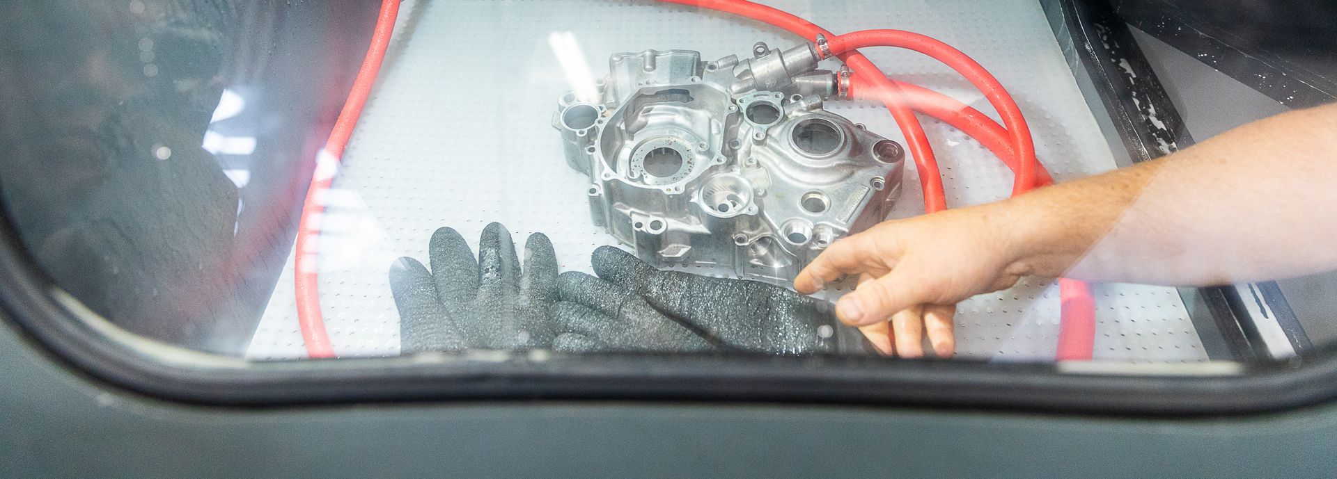 A person is pointing at a piece of metal in a car window.