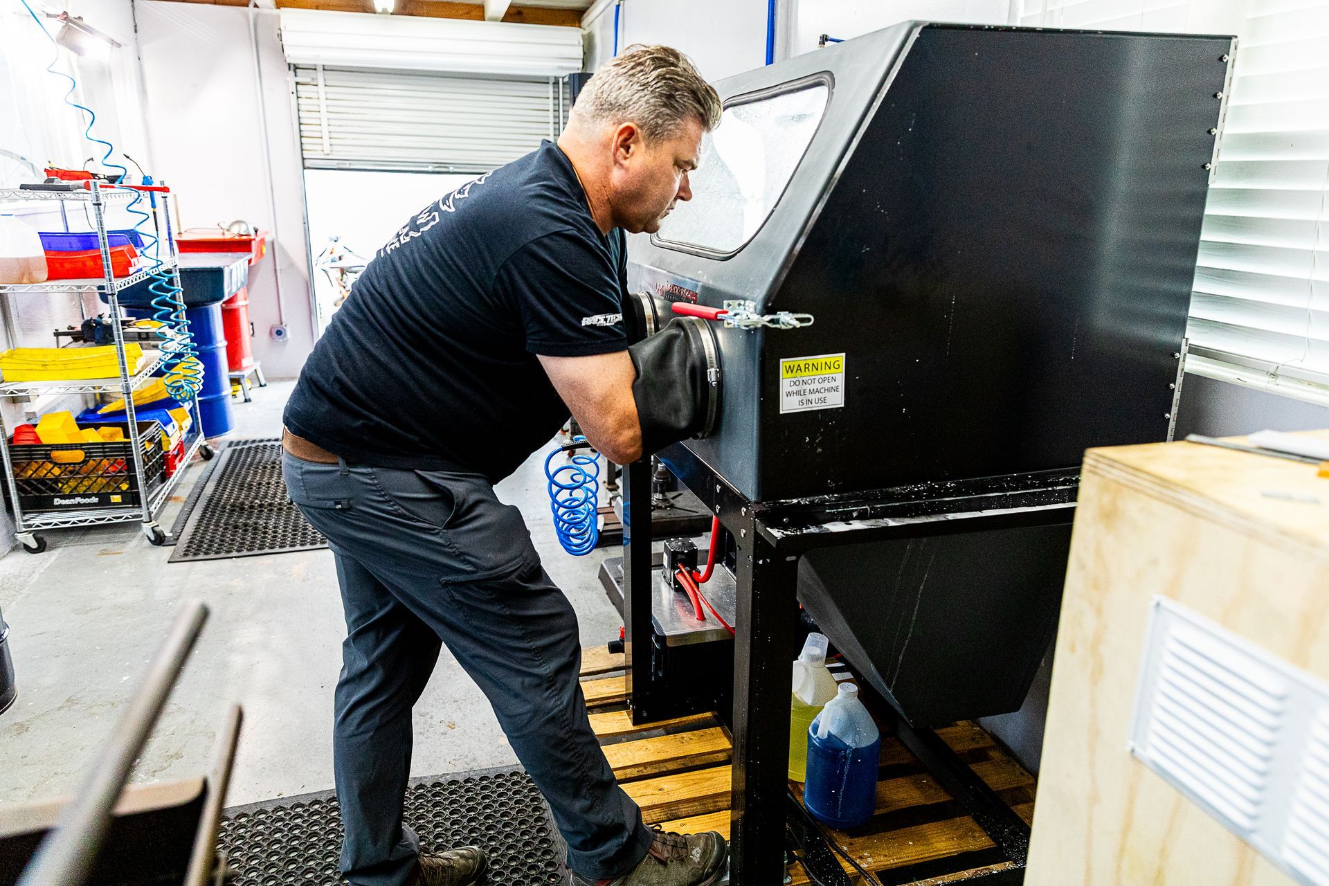 A man is working on a machine in a garage.