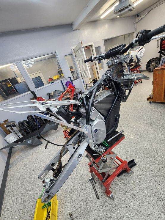 A motorcycle is sitting on a lift in a garage.