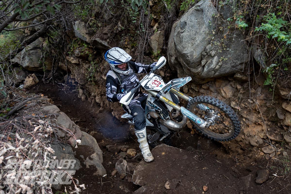 A person is riding a dirt bike on a dirt track.
