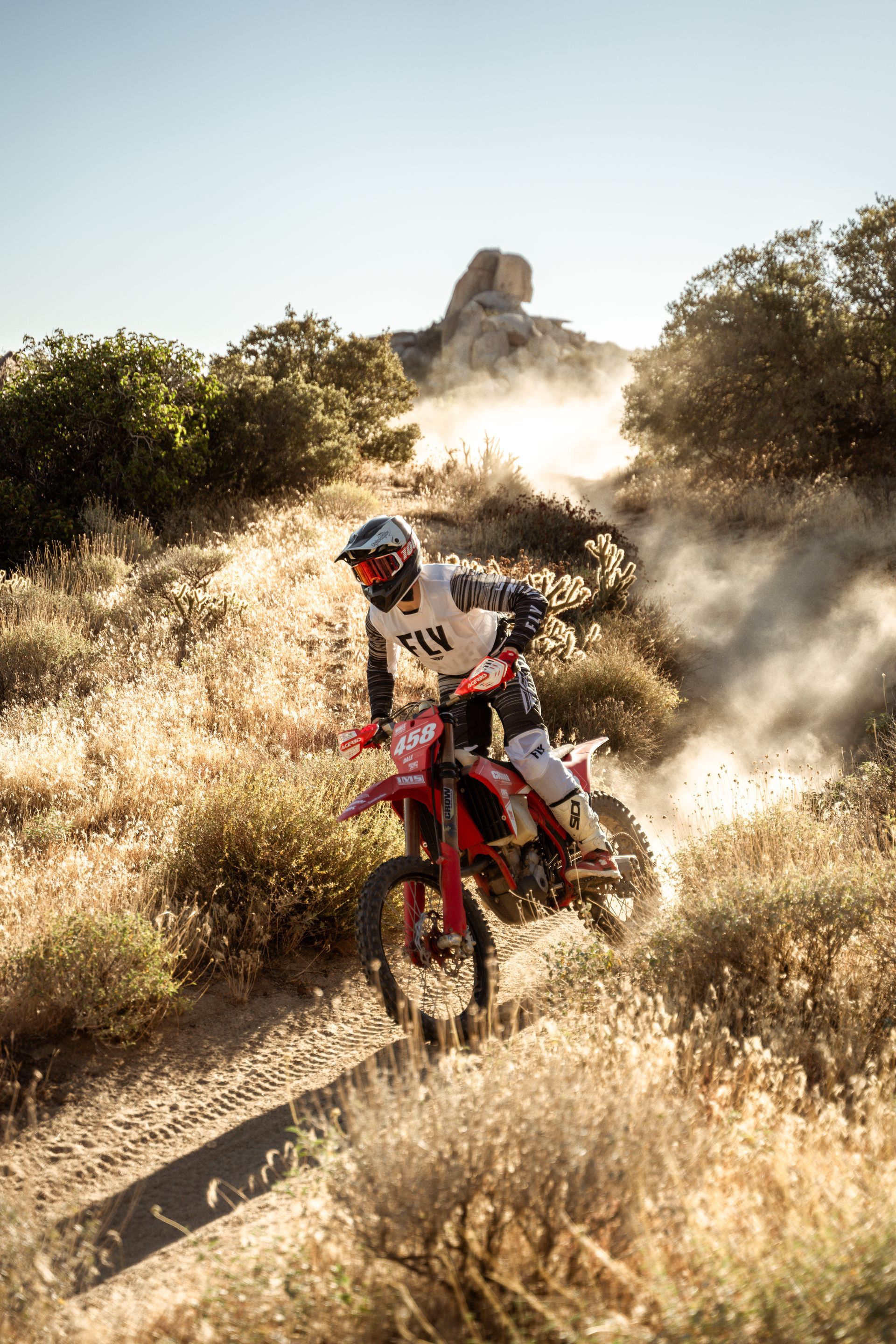 A person is riding a dirt bike on a dirt track.