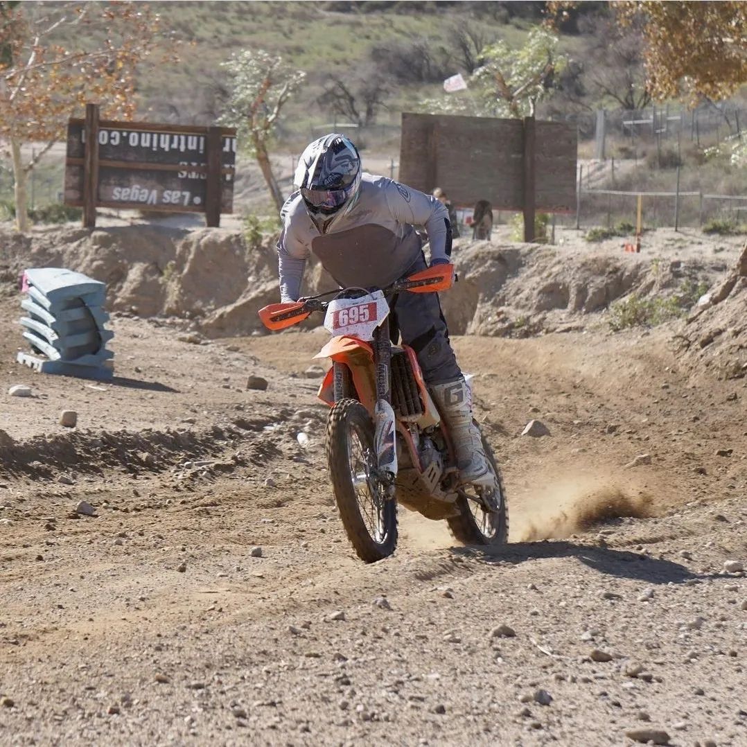 A man is doing a trick on a motorcycle on a road.