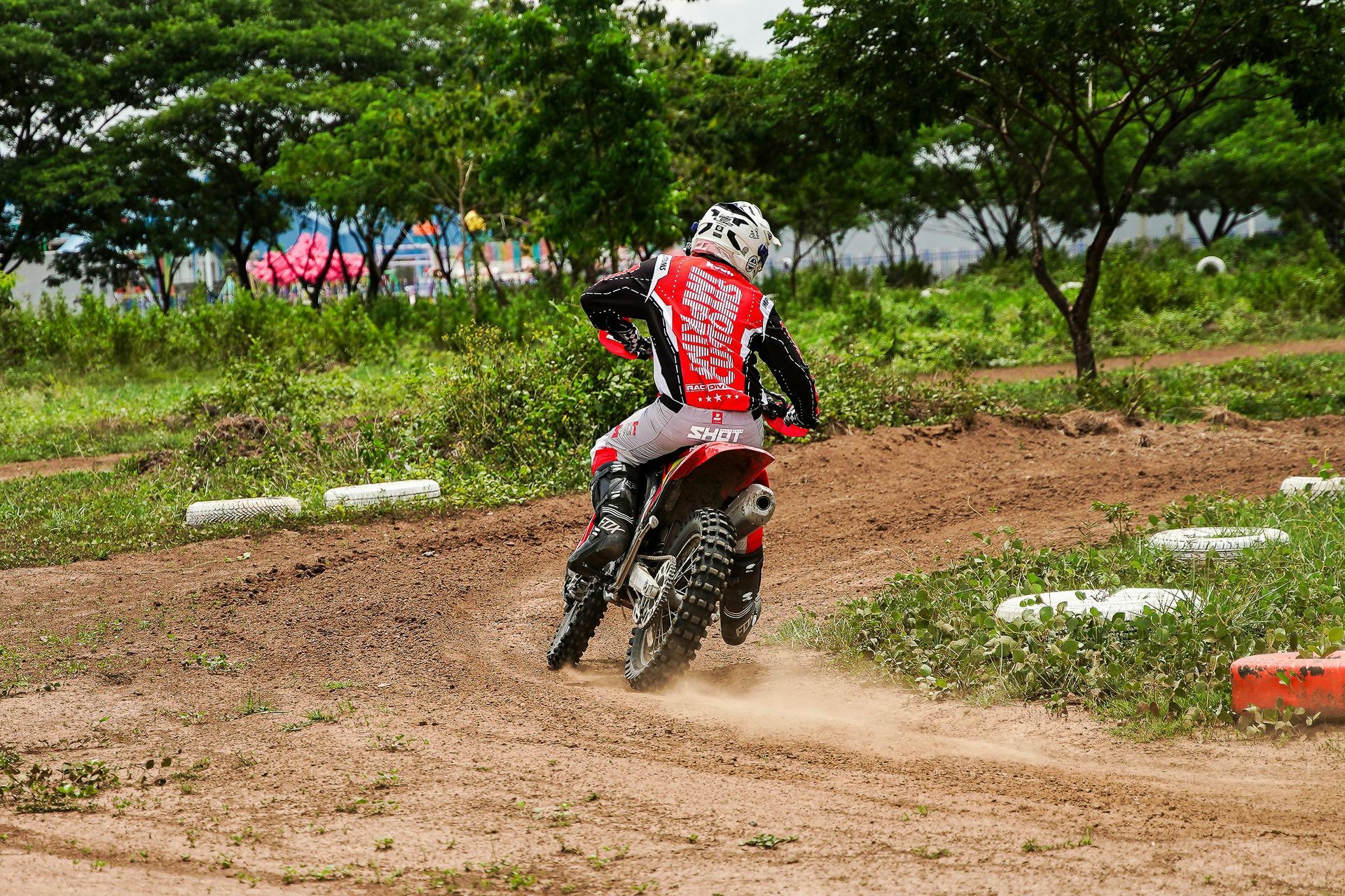A man is riding a dirt bike on a dirt road.