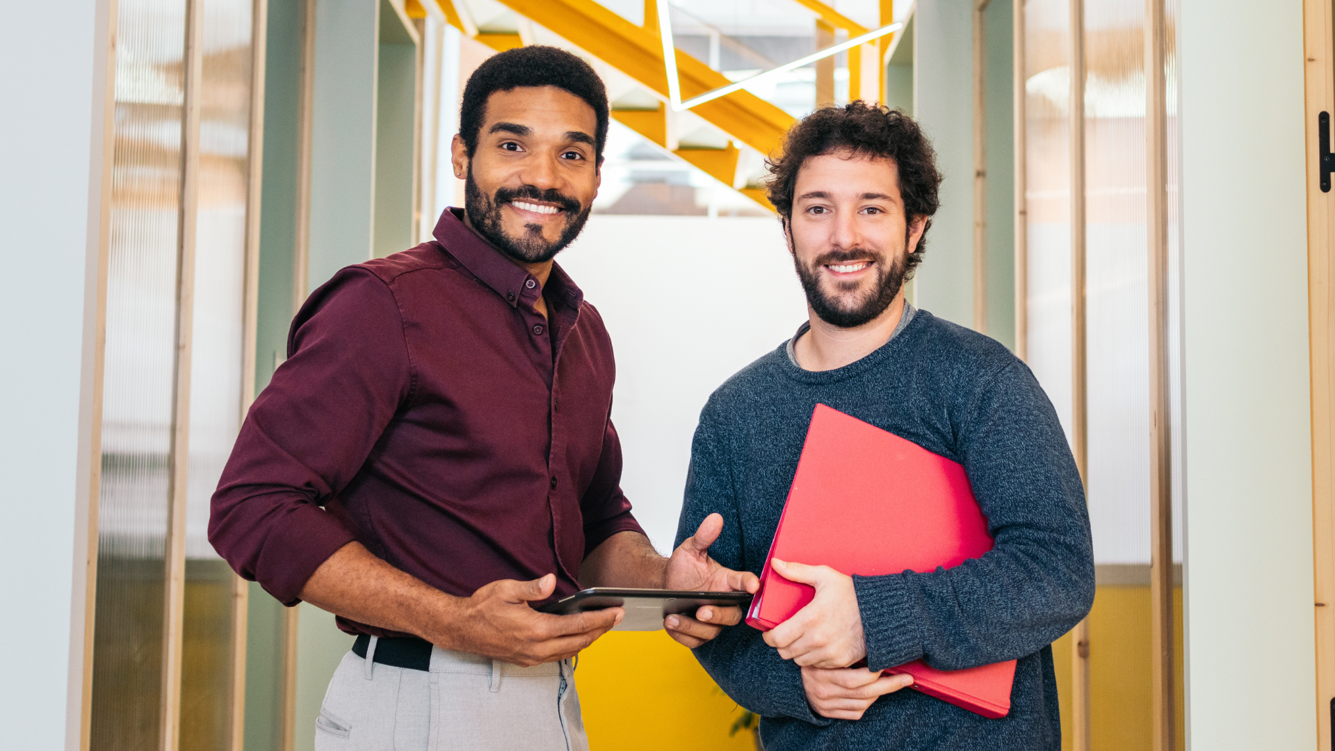Two colleagues smiling in an office discussing IT hiring — permanent vs contract roles