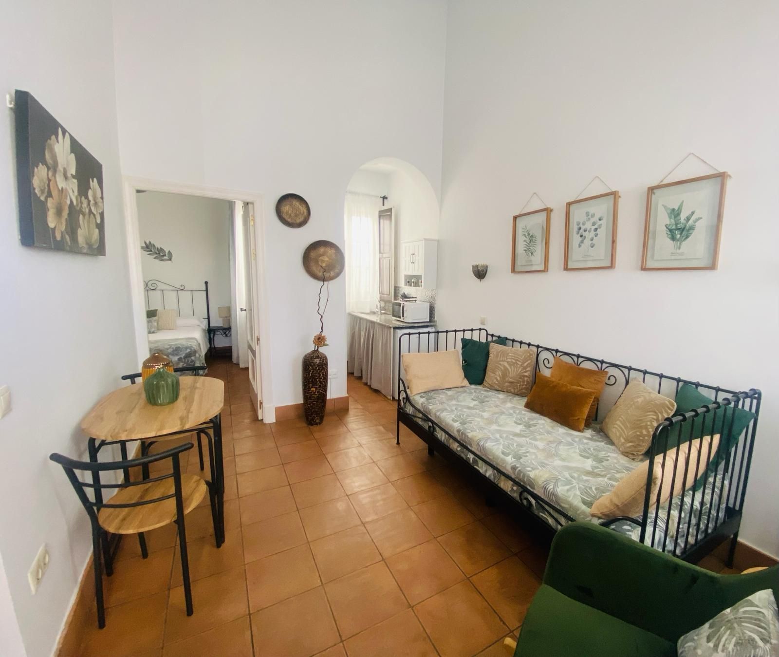 Acogedor interior de apartamento con comedor, sala de estar y vista a un dormitorio y una cocina.