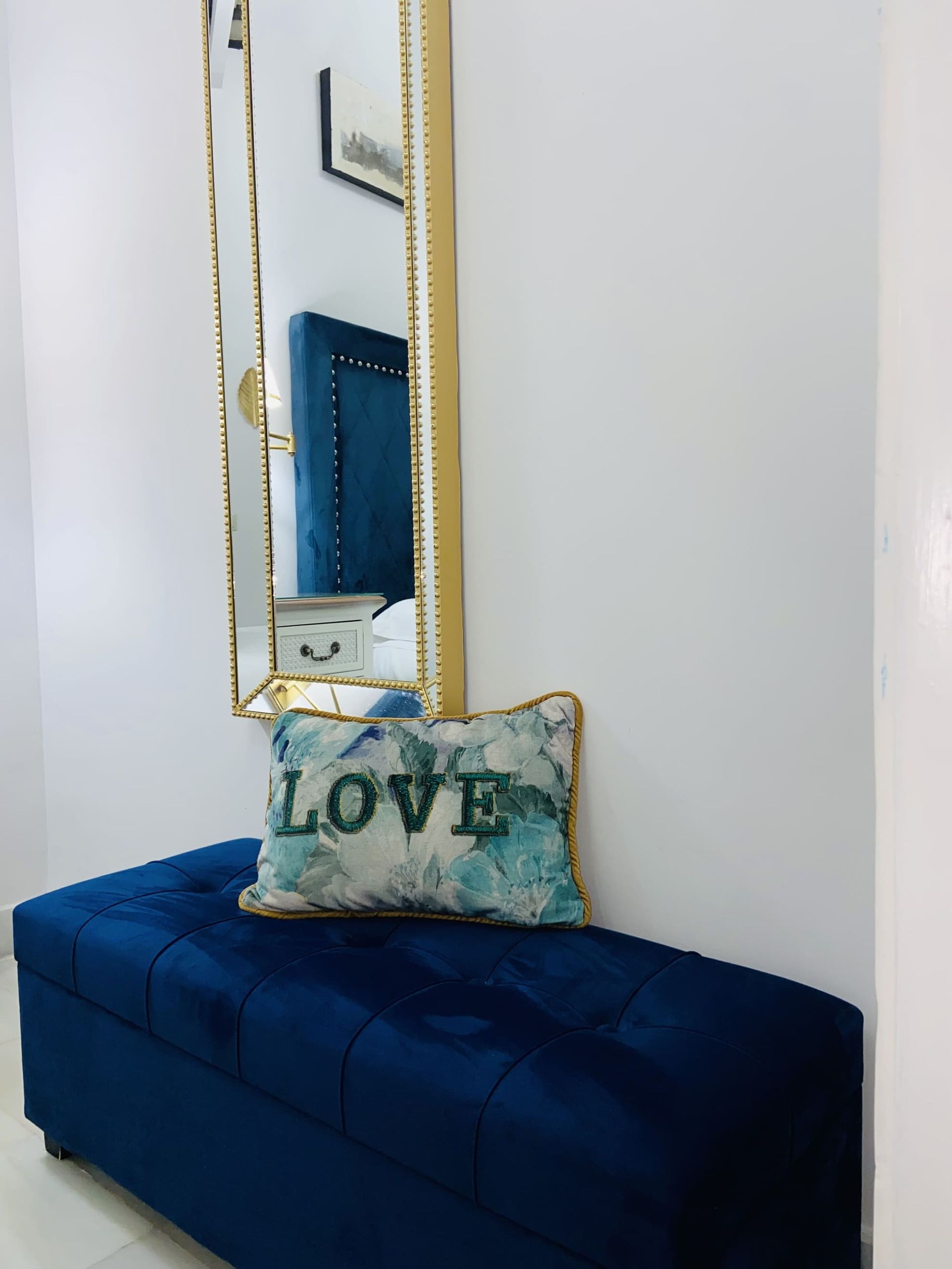 Banco de terciopelo azul con una almohada 