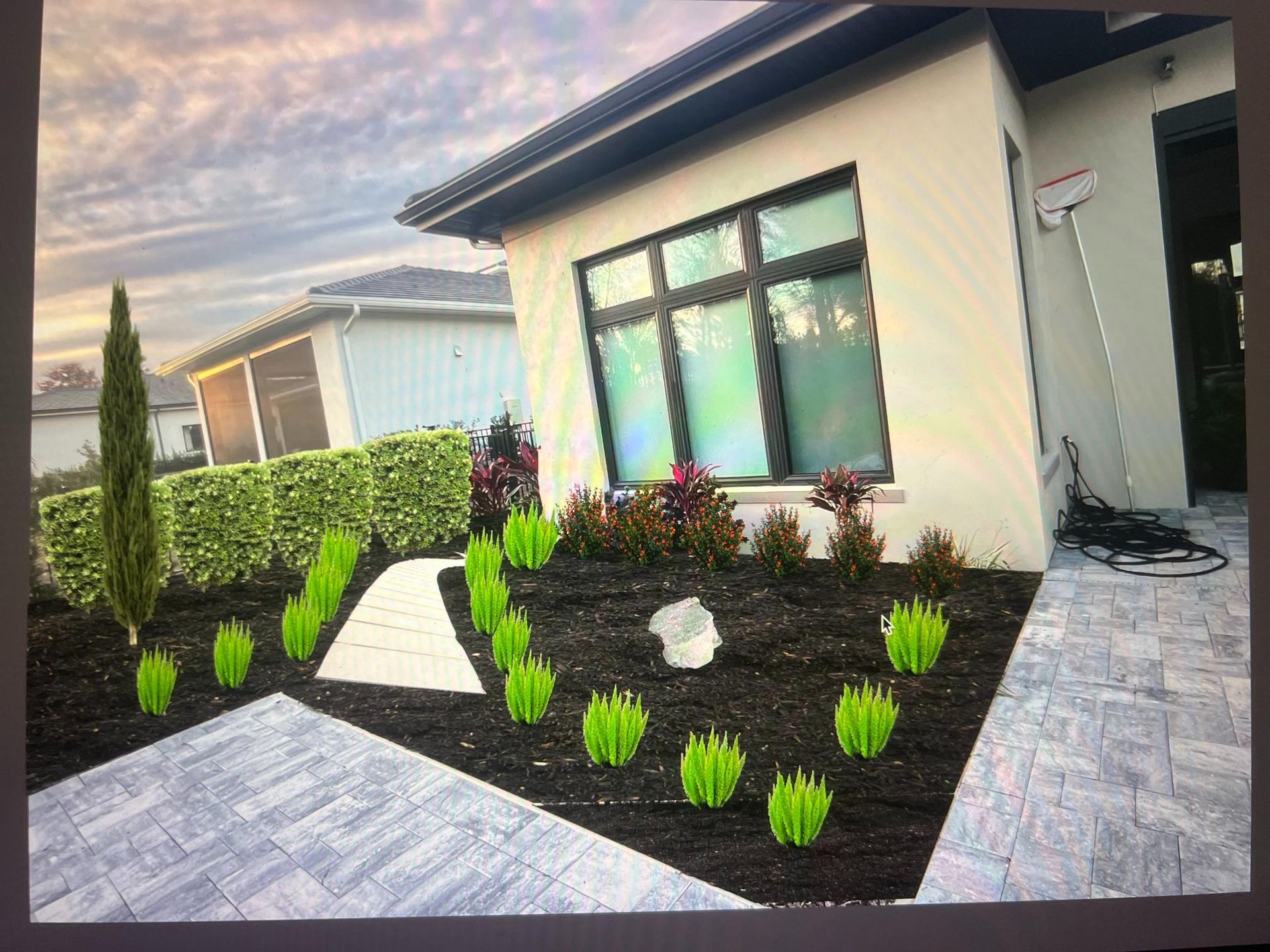 Landscaped front yard with walkway and plants in front of a modern home.