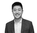 Un homme en costume et chemise blanche sourit sur une photo en noir et blanc. client chez push push propreté