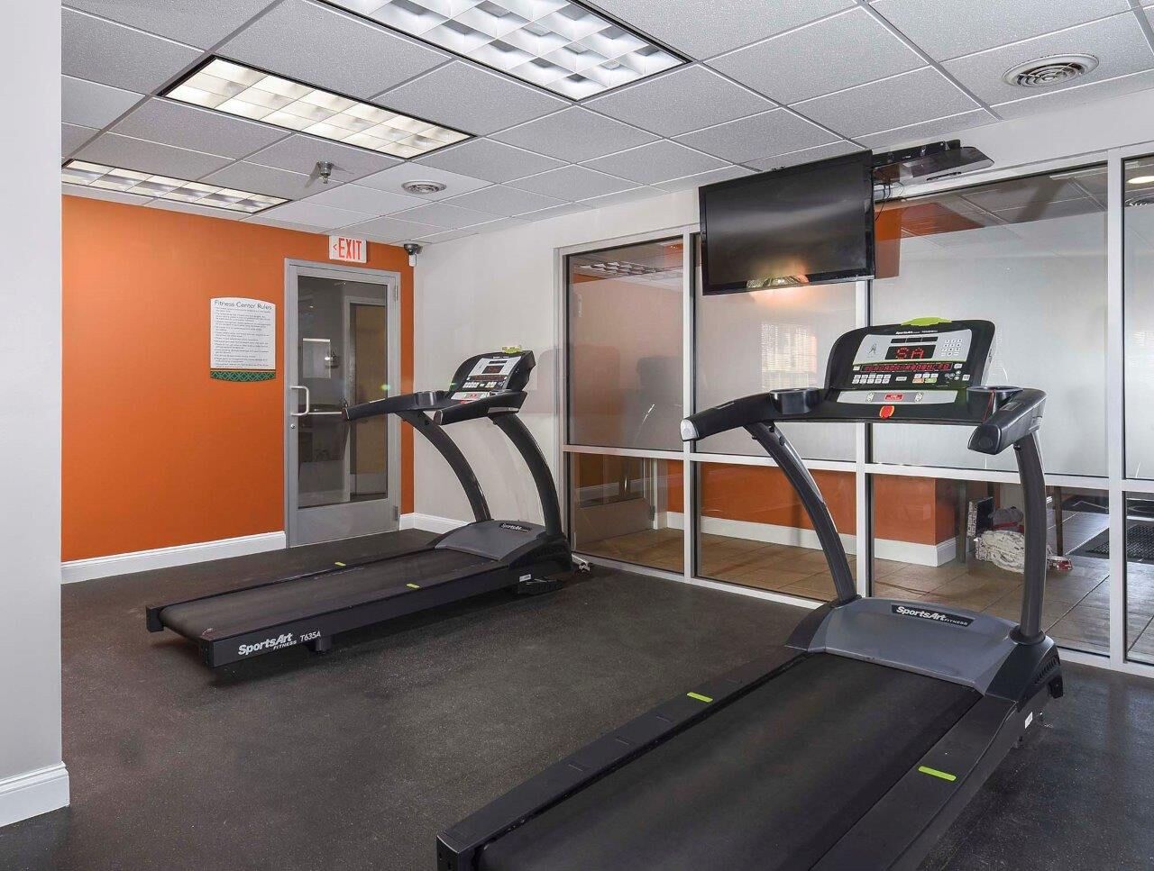 Interior fitness center with two treadmills and a wall-mounted TV at The Alden South Hills in Pittsburgh, PA. 
