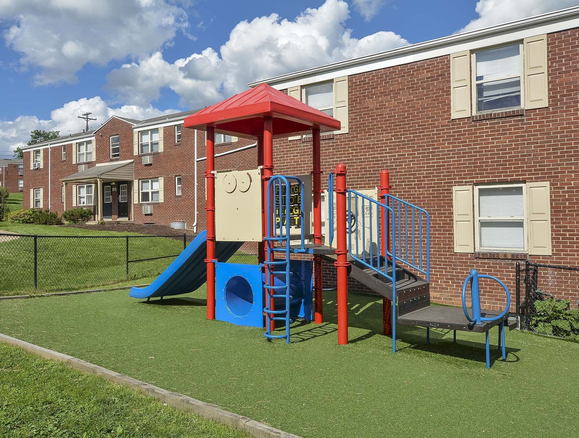 Colorful playground with slide and climbing structure in apartment complex courtyard at The Alden South Hills in Pittsburgh, PA. 
