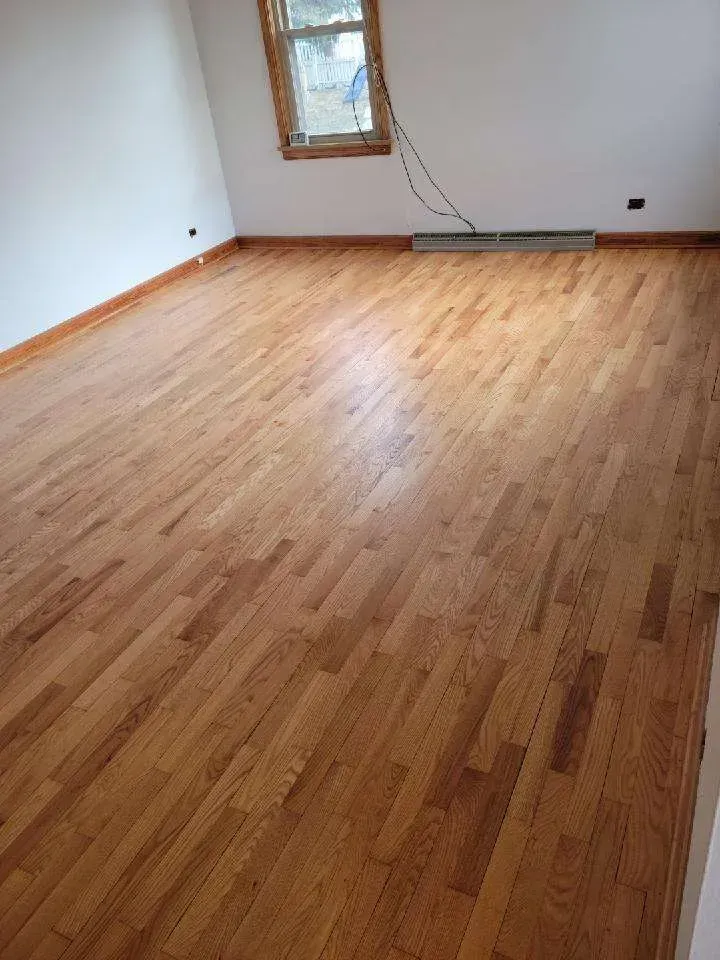 A living room with hardwood floors and white walls.