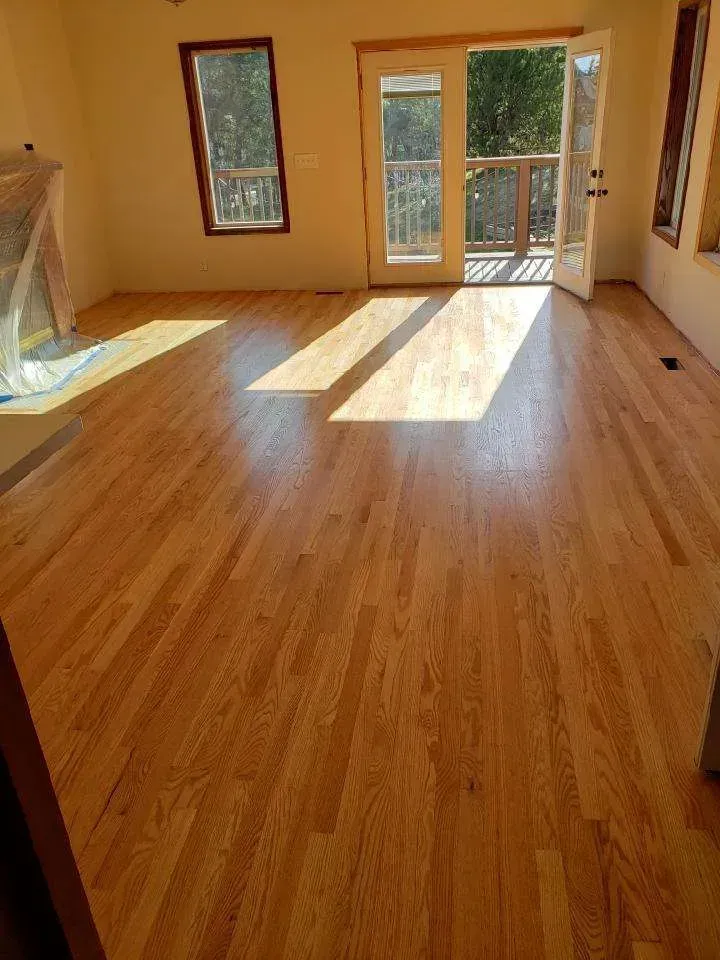 A living room with hardwood floors and sliding glass doors.