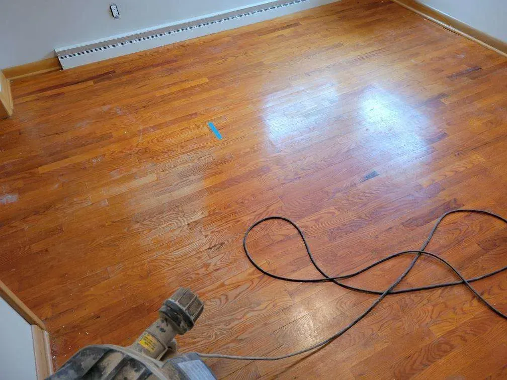 A vacuum cleaner is sitting on a wooden floor in a room.