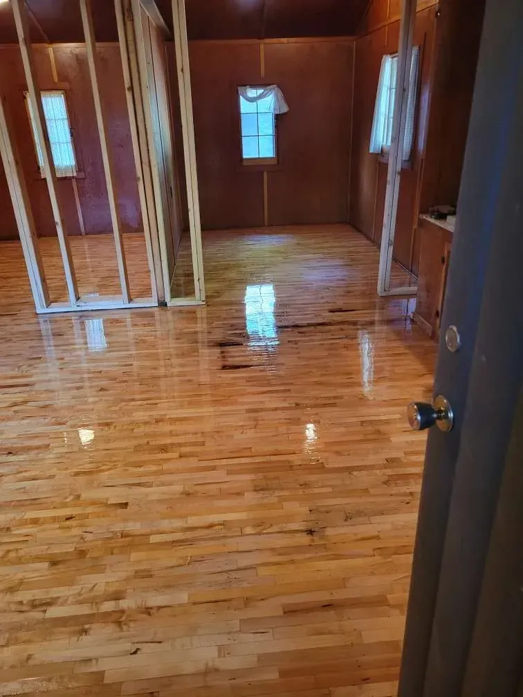 A room with a wooden floor and a window.