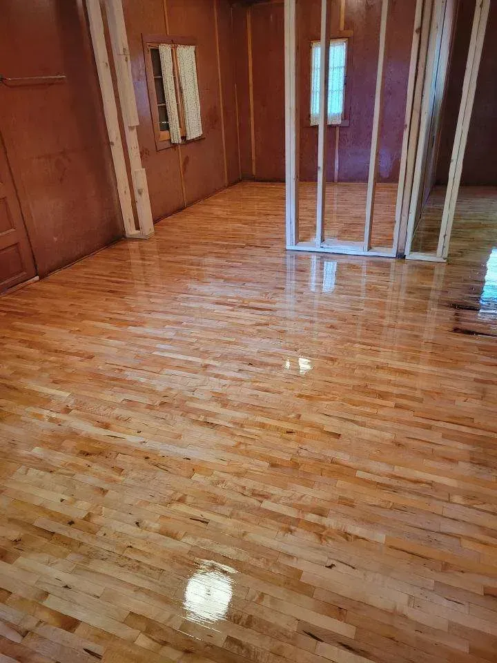 A room with a wooden floor and a window.