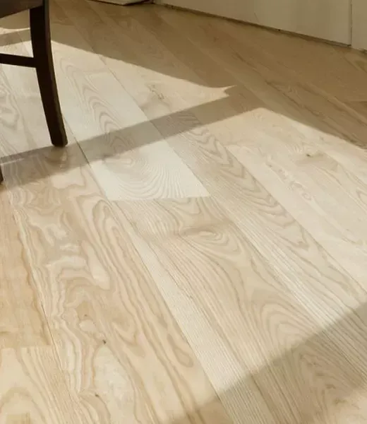 A wooden floor with a chair in the background