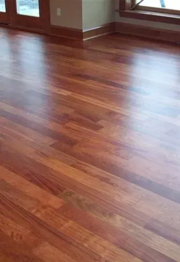 A living room with a wooden floor and a window.