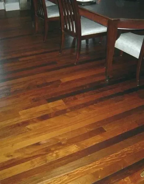 A wooden floor with a table and chairs on it