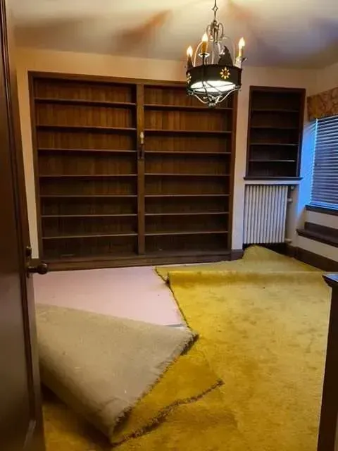 A room with a lot of shelves and a chandelier.