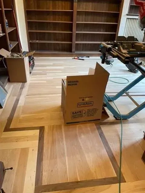 A cardboard box is sitting on a wooden floor in a room.
