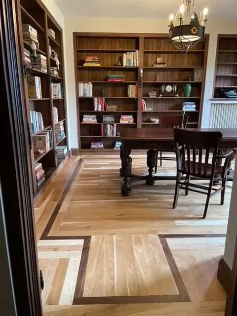 A room with a table , chairs , shelves and a chandelier.