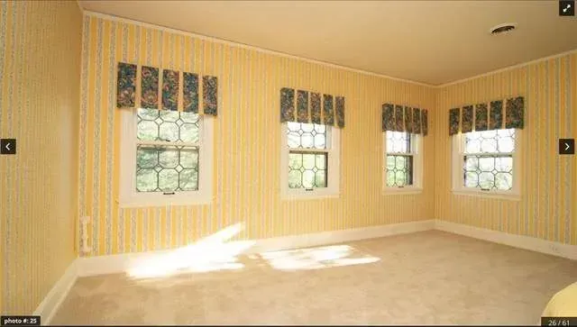 A room with a lot of windows and yellow walls