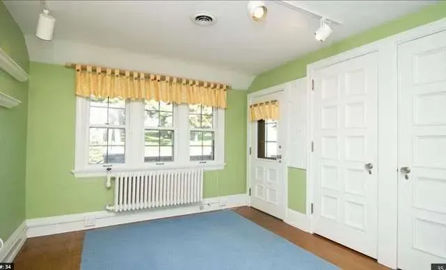 An empty room with green walls and white doors