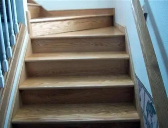 A set of wooden stairs with a white railing