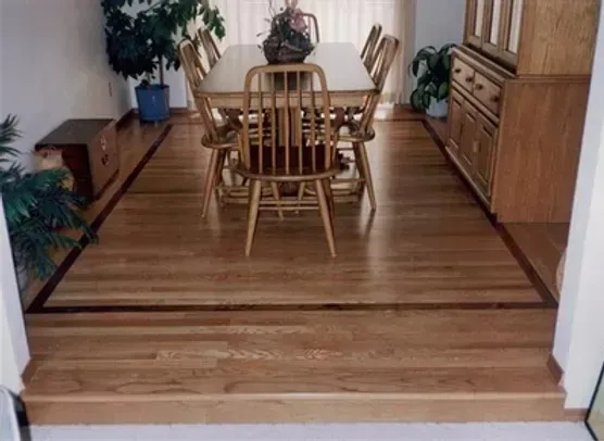 A dining room with a wooden table and chairs