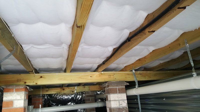 A Man in a Red Shirt Is Working on a Wall | East Gosford, NSW | Clark’s Insulations