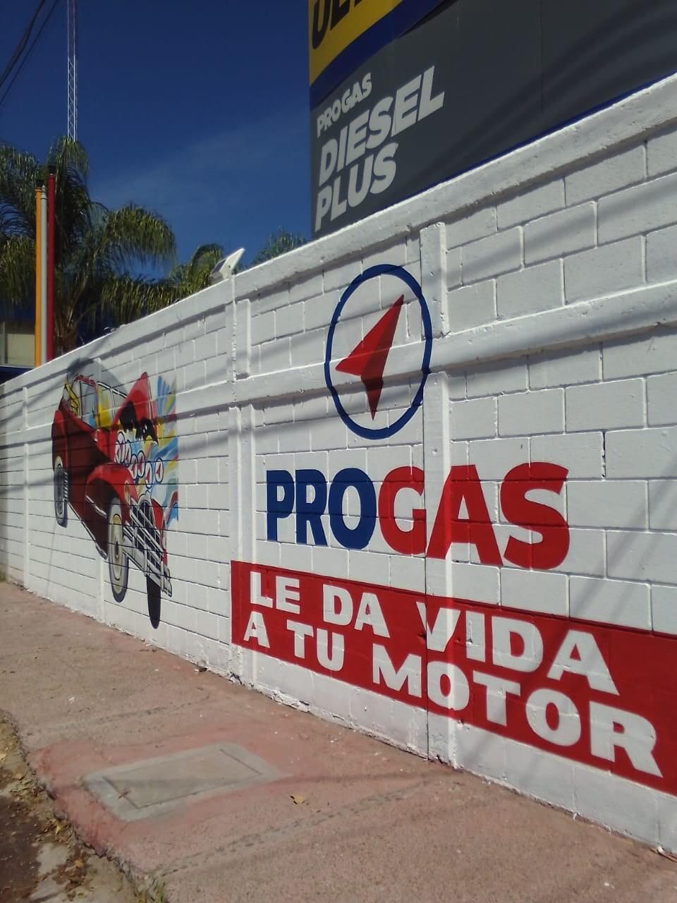 Una pared de ladrillos con un cartel progas en ella