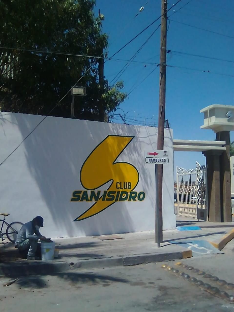 Una pared blanca con un rayo amarillo que dice club san isidro